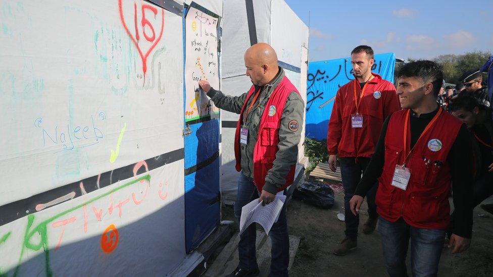 French authorities inspect a structure in the camp before the demolition.