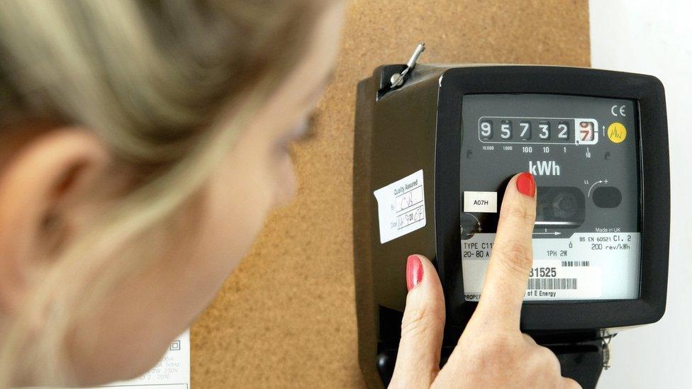 A woman points at an energy meter