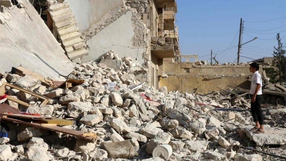 A young Syrian looks at the rubble of a collapsed building as rescuers look for victims after a reported air strike on the Sakhur area of northern Aleppo 19/07/2016