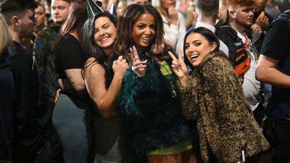 Revellers pose for a photo as they queue to enter Depot Mayfield, a 10,000 capacity club in Manchester