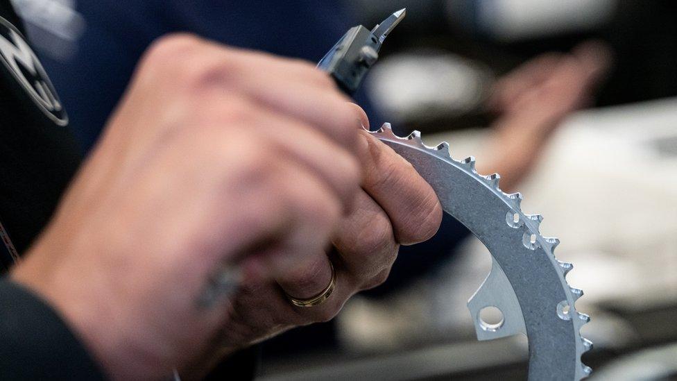 A bike front gear ring being tested by a Miranda employee