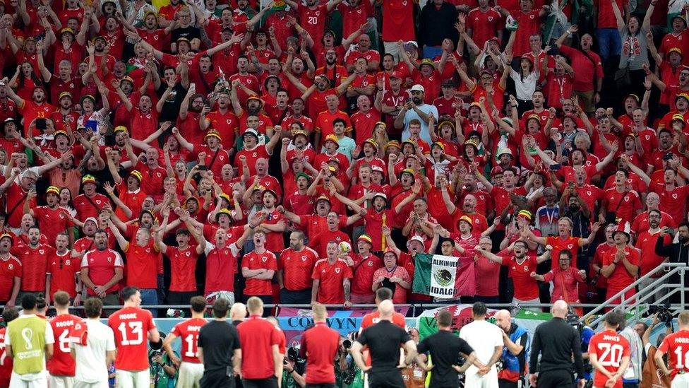 Wales players and staff salute the Red Wall of their fans after their World Cup exit