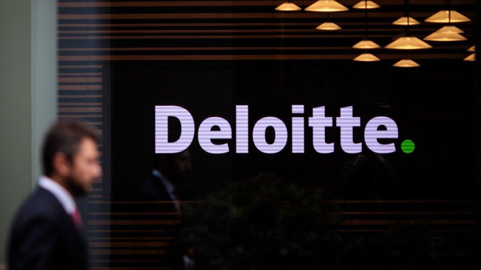 Man walks past Deloitte office