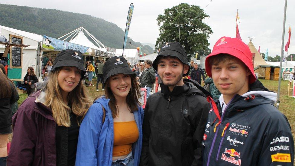 Pedwar o bobl ifanc gyda hetiau haul ar y Maes // Four young people with their beanie hats on the Maes