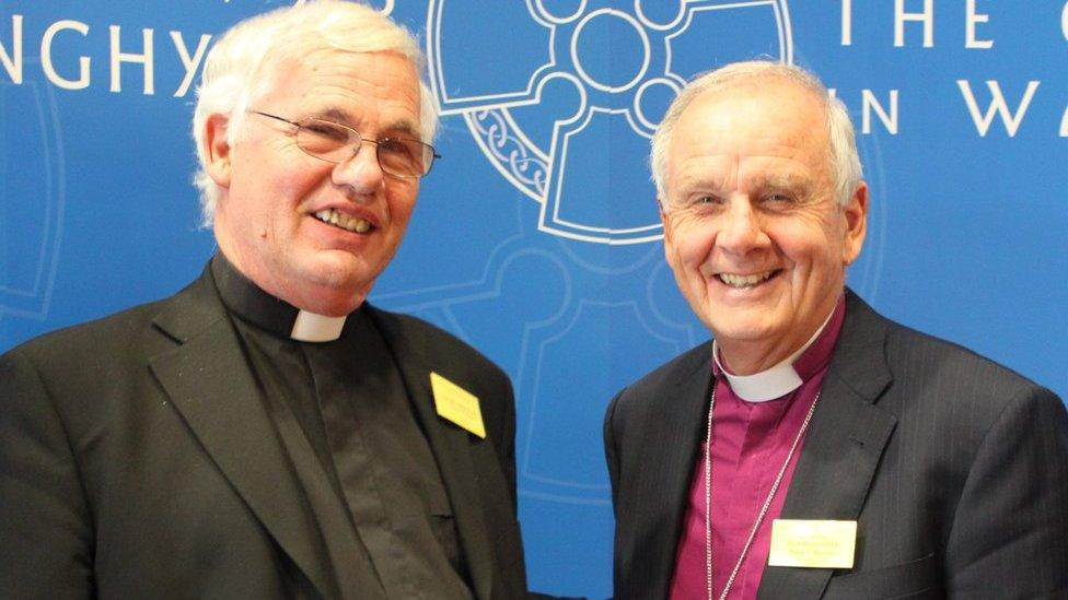 Archdeacon Philip Morris with the former Archbishop of Wales, Barry Morgan, both wearing clerical clothing and smiling at the camera 