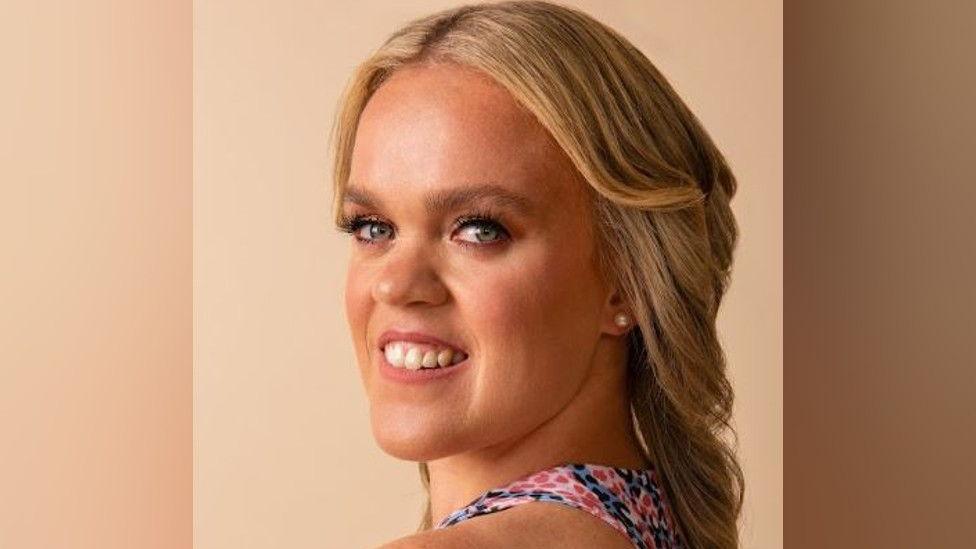 A close up of Ellie Simmonds, she is looking over her shoulder