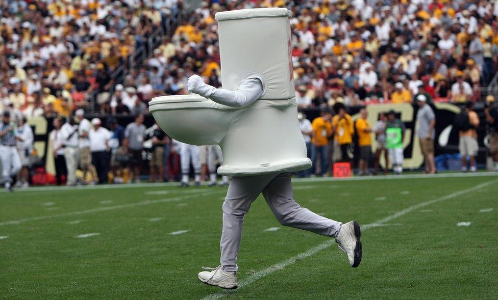 A man dressed as a toilet runs onto the field during an American football game in Denver, Colorado