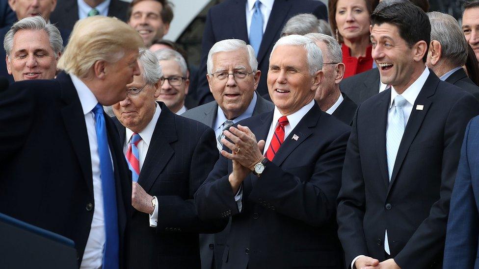 U.S. President Donald Trump (L) jokes with Senate Majority Leader Mitch McConnell (R-KY), Sen. Mike Enzi (R-WY), Vice President Mike Pence, Spaker of the House Paul Ryan (R-WI) and Sen. Tim Scott (R-SC) during an event celebrating the passage of the Tax Cuts and Jobs Act on the South Lawn of the White House December 20, 2017 in Washington, DC.