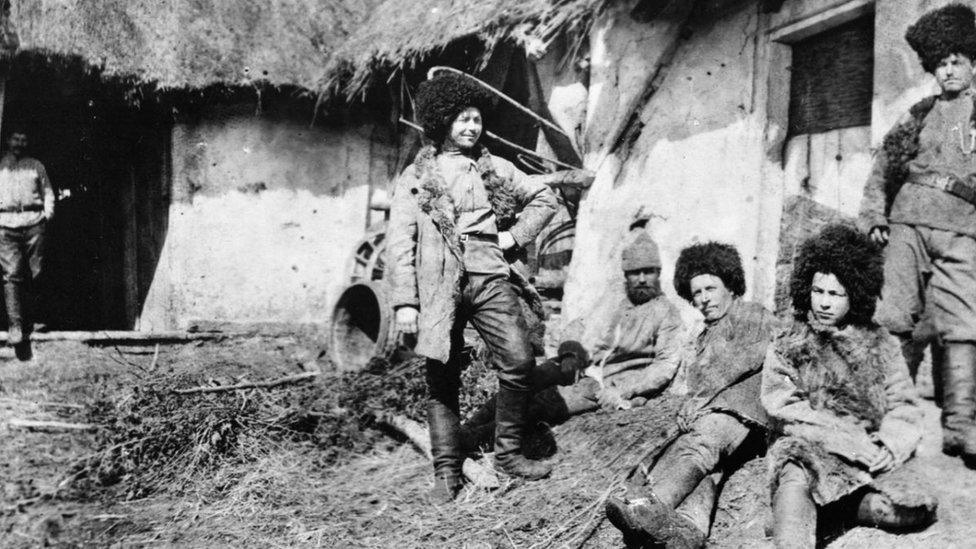 Russian Cossack troops in winter uniforms outside their accommodation huts