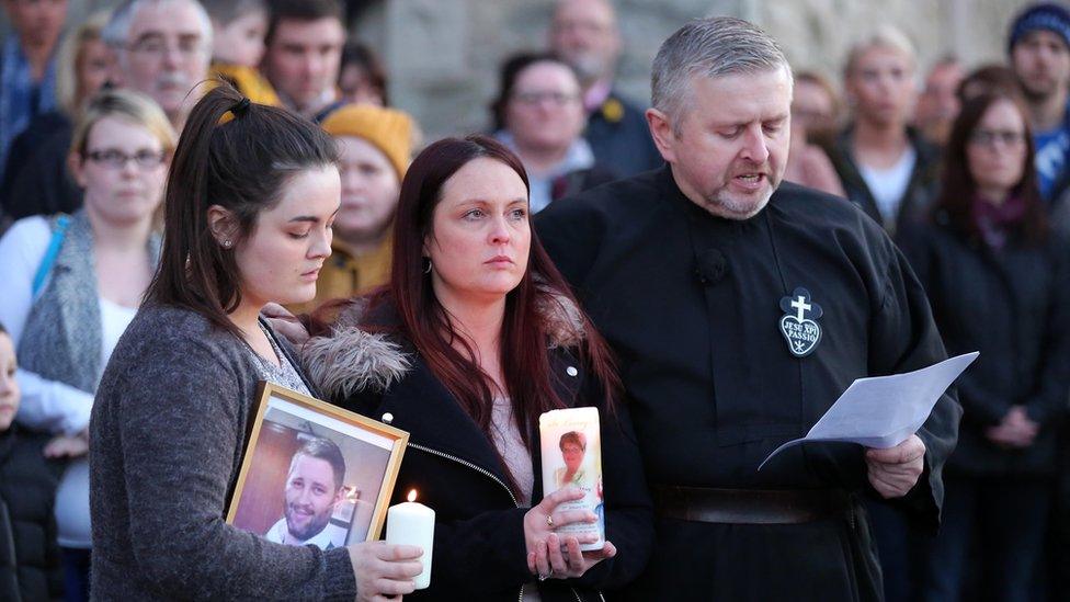 Fr Gary Donegan at a vigil for murdered man Michael McGibbon, with the victim's widow Joanne