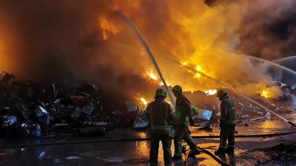 Firefighters working at the scene of a fire which broke out in a scrap metal recycling business at the Belfast Harbour estate