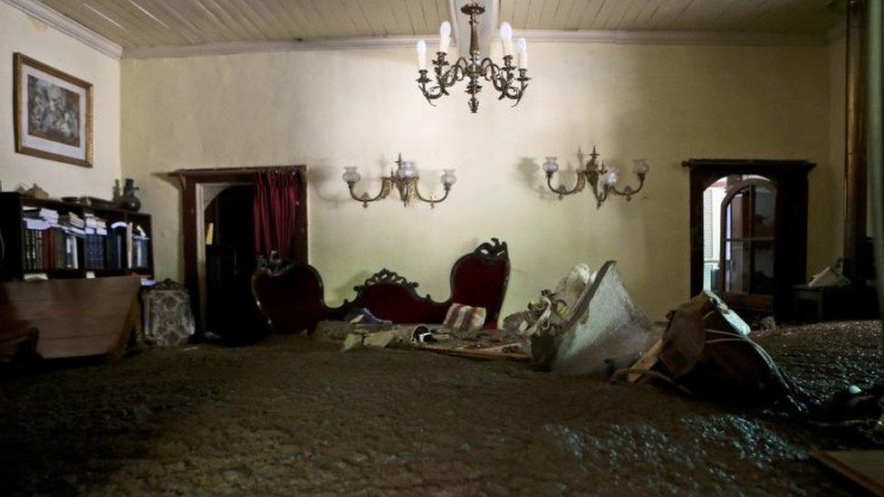 Sludge fills a living room after the overflowing of the Estero San Jose River in San Alfonso, Santiago, Chile, Sunday, Feb. 26, 2017