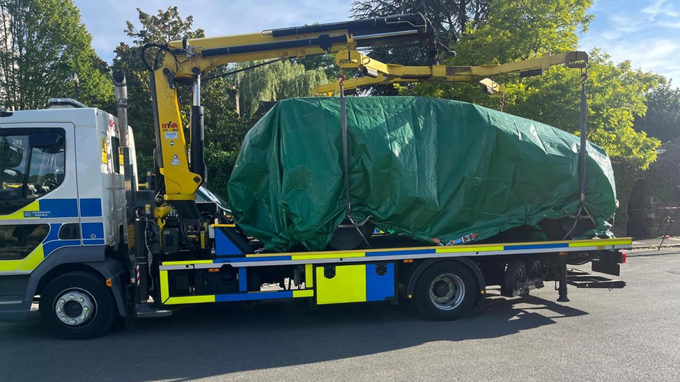 Image of a police lorry equipped with a small crane outside The Study school.