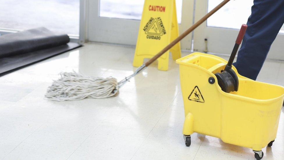 A cleaner with a mop and bucket