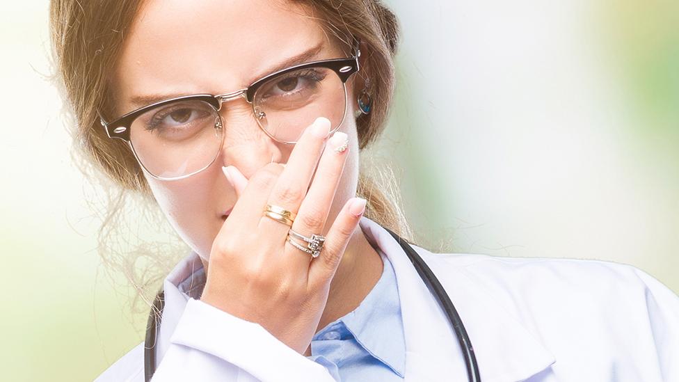 Health worker holding nose