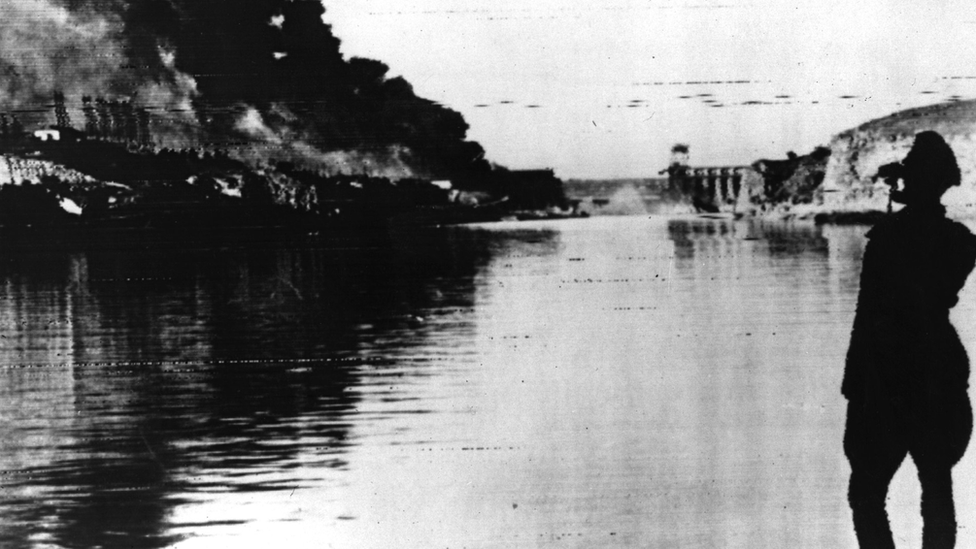 A German officer looks at the flooding caused by the destruction of the dam at Zaporizhzhia in 1941