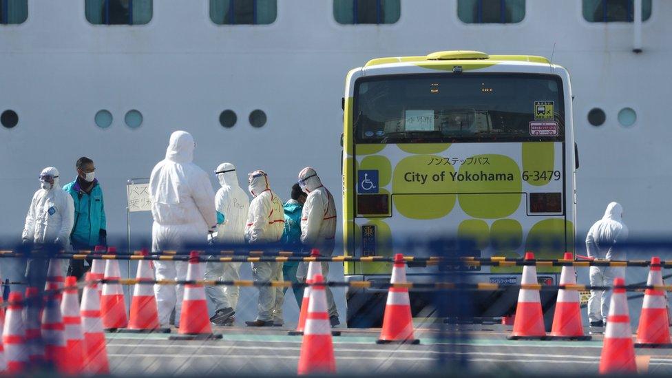 Workers in protective gear are seen near the cruise ship Diamond Princess at Daikoku Pier Cruise Terminal in Yokohama, south of Tokyo, Japan February 19, 2020.