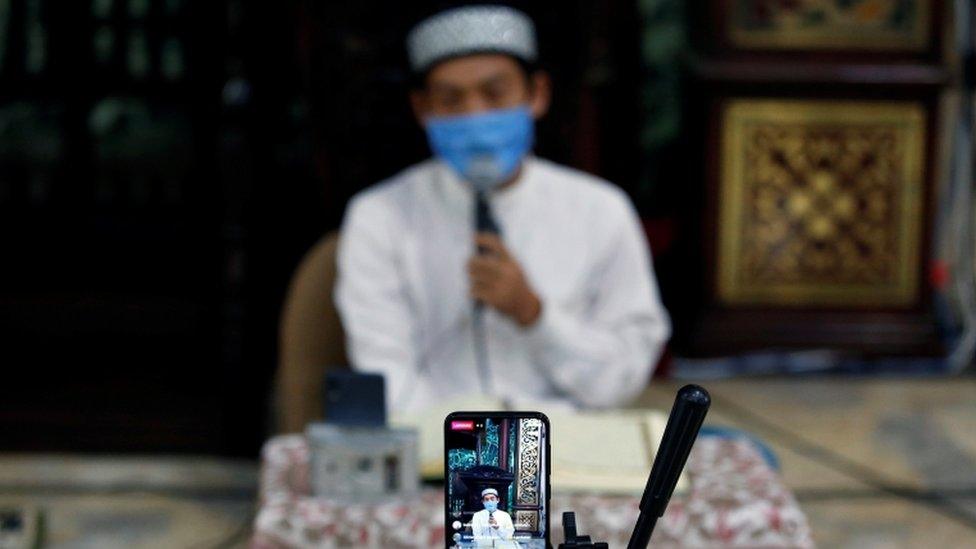 An imam in Indonesia broadcasts a recitation of the Koran