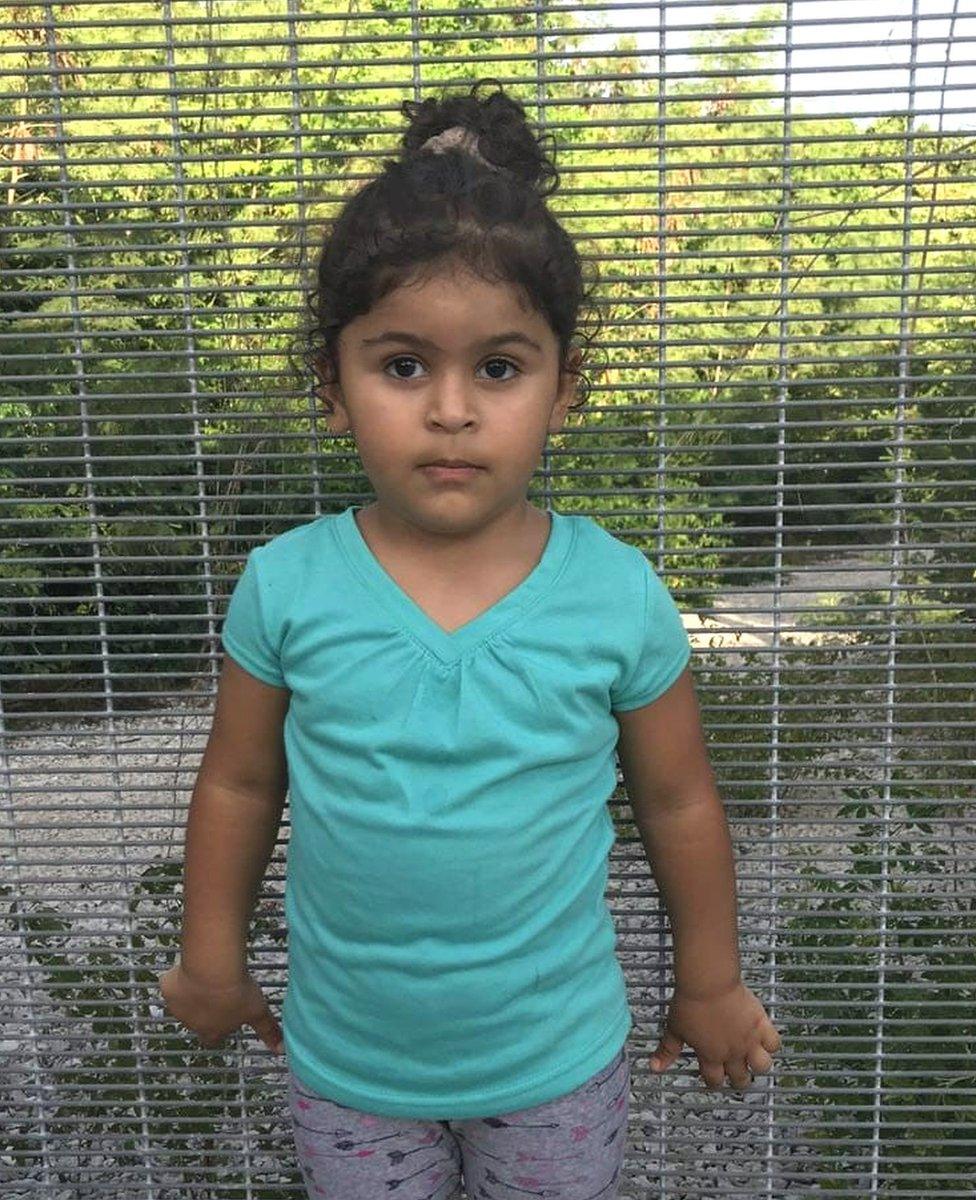 Three year old Melanie stands in front of a fence in the island of Nauru