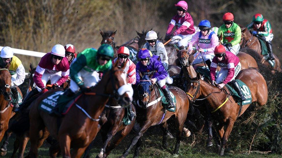 Horses and riders jump Canal Turn during the Grand National at Aintree Racecourse on April 14, 2018