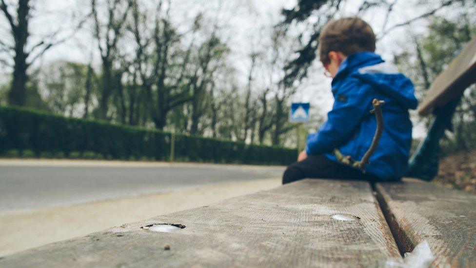 Child sitting on public bench (generic)