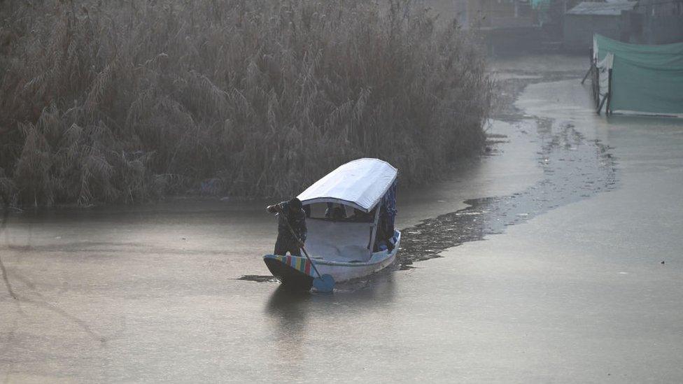 Boatmen use oars to break an partially frozen surface of Dal Lake on a cold morning on January 5, 2023 in Srinagar, India. Temperatures dip further in Kashmir, Srinagar records seasons coldest night at Minus 6.4.(Photo By Waseem Andrabi/Hindustan Times via Getty Images)