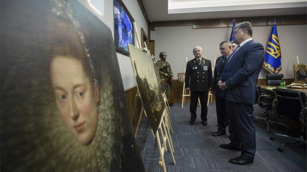 Ukrainian President Petro Poroshenko (front) looks at the recovered paintings. 11 May 2016