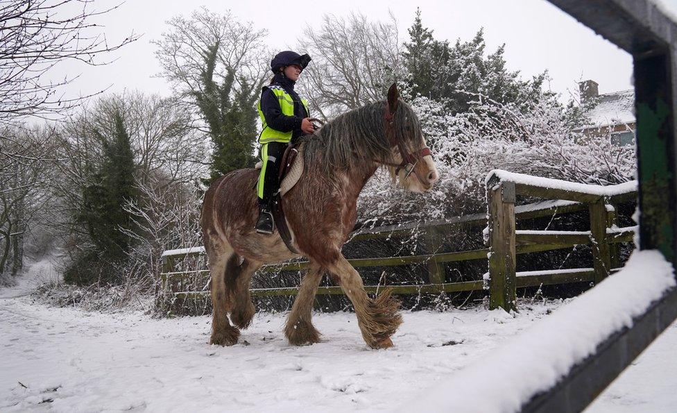 A woman rides a horse through the snow near Castleside, County Durham.