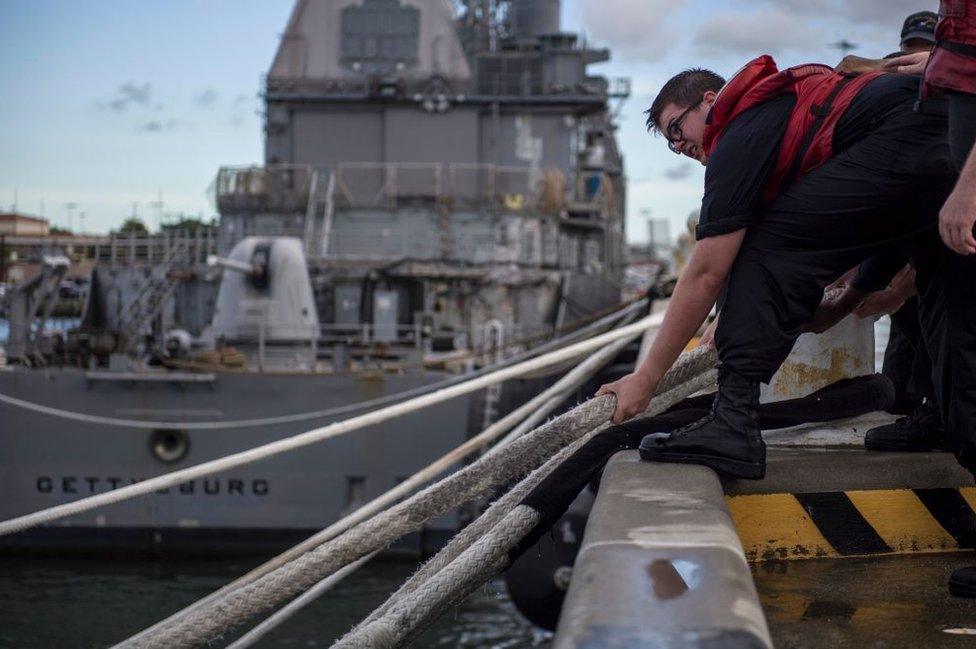 Navy ships that cannot go to sea are secured to the Norfolk, Virginia, port with heavy moorings