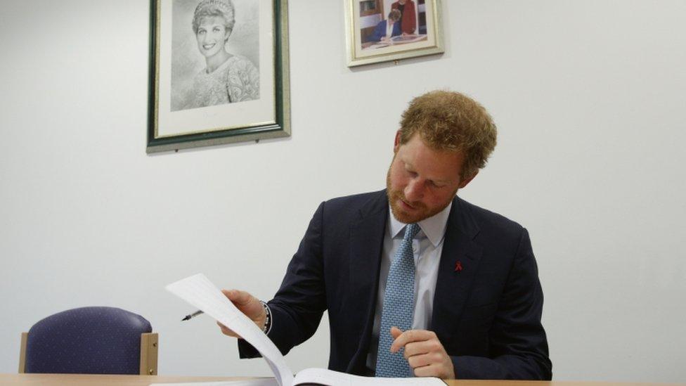 Prince Harry signs a visitors book