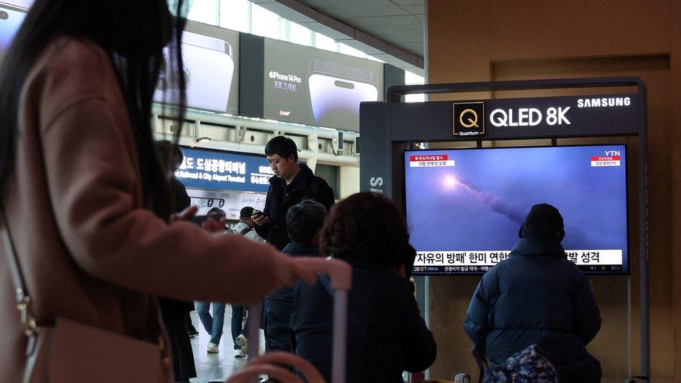 People watching a news report on the missile