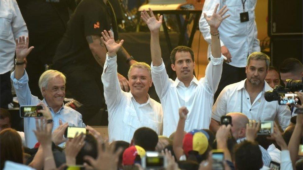 Chilean president Sebastian Pinera, Colombian President Ivan Duque, Venezuela's opposition leader Juan Guaido and Paraguayan president Mario Abdo Benitez wave at the "Venezuela Aid Live" concert, organized to raise money for the Venezuelan relief effort, at the head of the Tienditas International Bridge in Cucuta, Colombia, on February 22, 2019