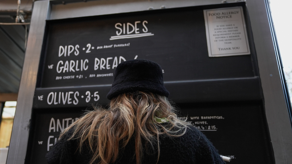 Someone reading a chalk board menu