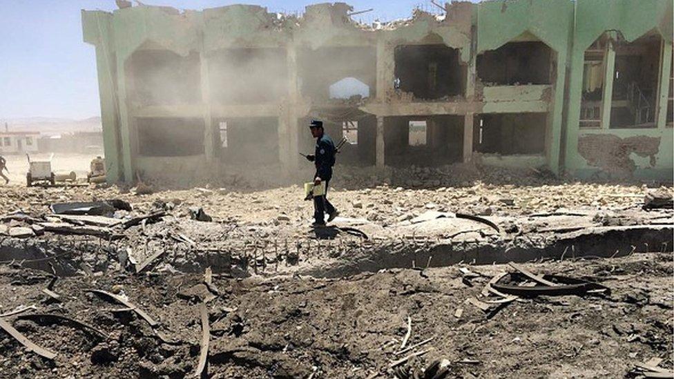 An Afghan policeman inspects the site of a suicide attack in Zabul on 25 May 2015