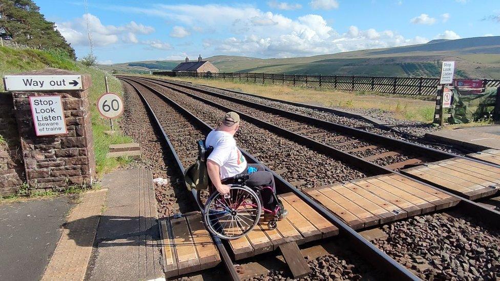 Doug Paulley crossing the rail line in his wheelchair