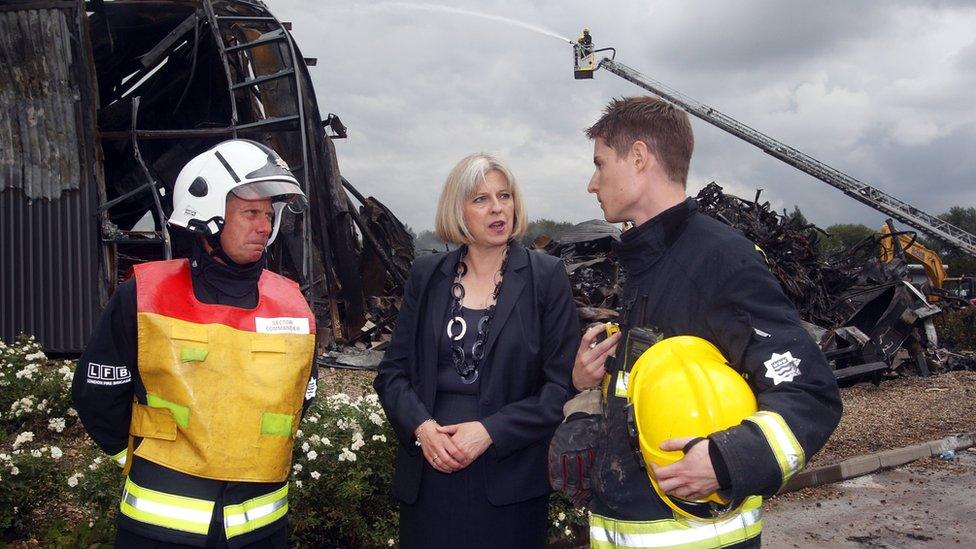 ˿ Secretary Theresa May talking to two firefighters