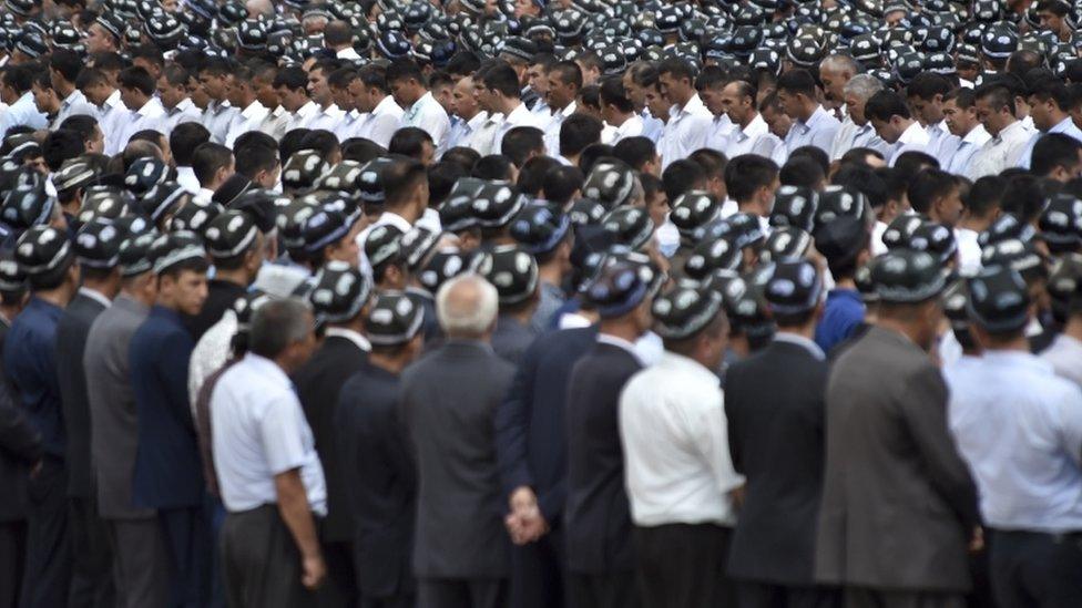 Uzbek men pay respects in Registan square in Samarkand, Uzbekistan