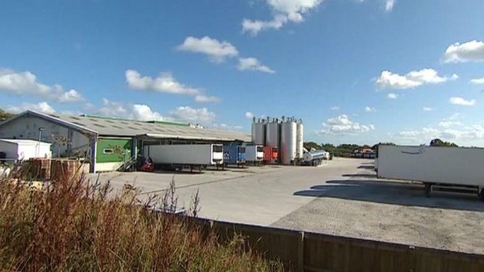 Lorries parked outside the Trewithen Dairy factory with steel milk storage vessels in the background