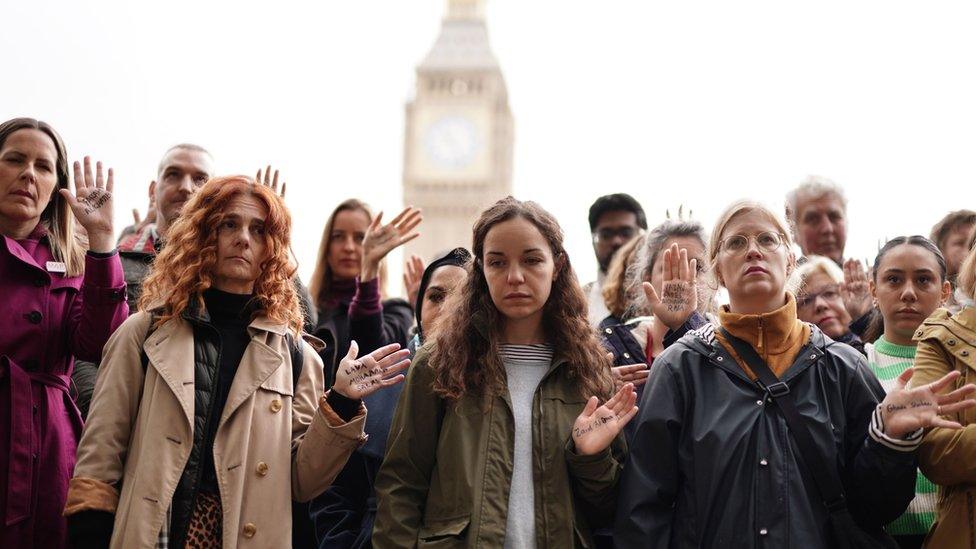 People take part in a vigil organised by Medical Aid for Palestinians at Parliament Square