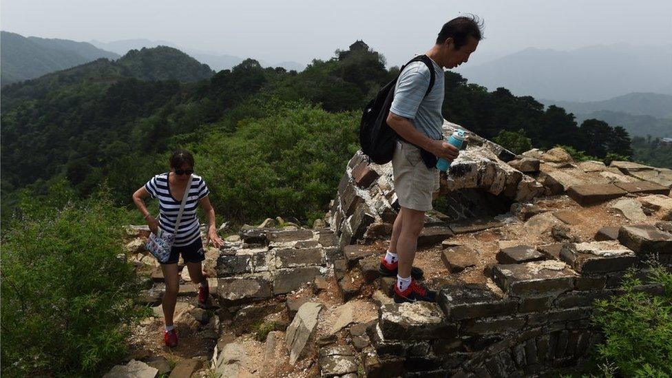 Tourists on an un-restored section of the wall