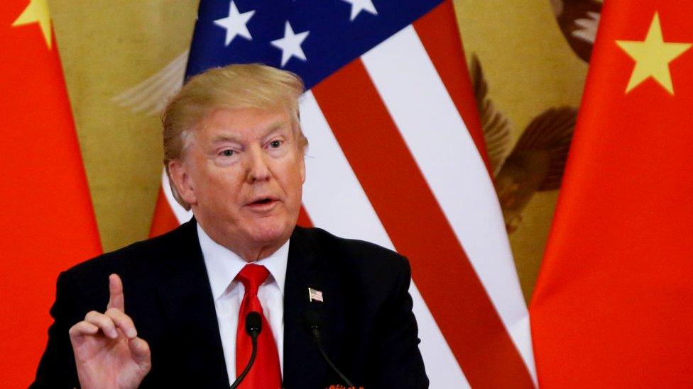 Donald Trump in front of US and Chinese flags