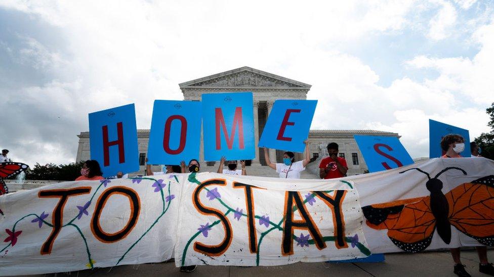 Activists hold up a sign reading Home outside the US Supreme Court