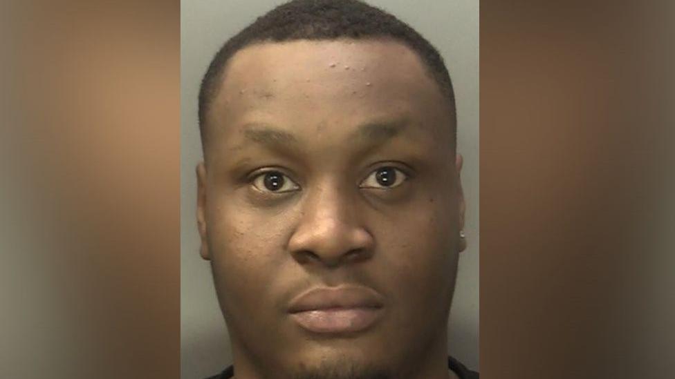 a mugshot of Javonnie Tavener. he has short black hair and is looking at the camera