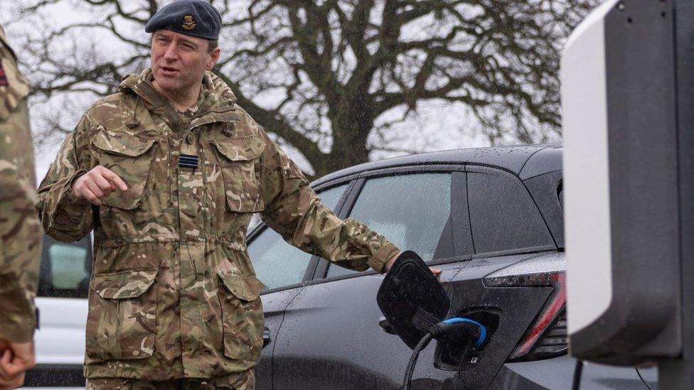 Soldier charging an electric car