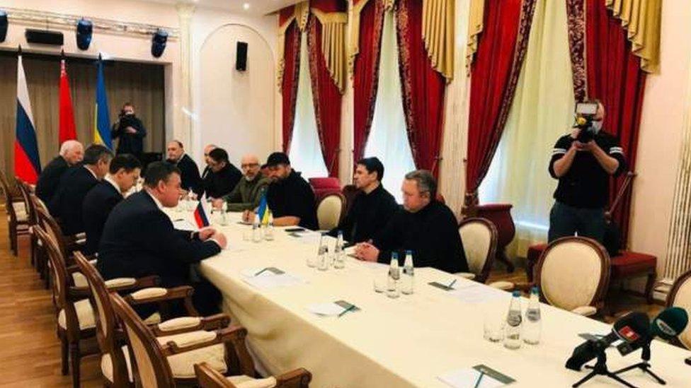 Ukraine and Russian officials sit on opposite sides of a table