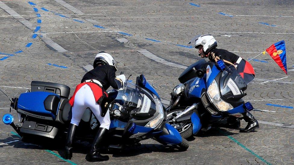 Gendarmes pick up their bikes after colliding