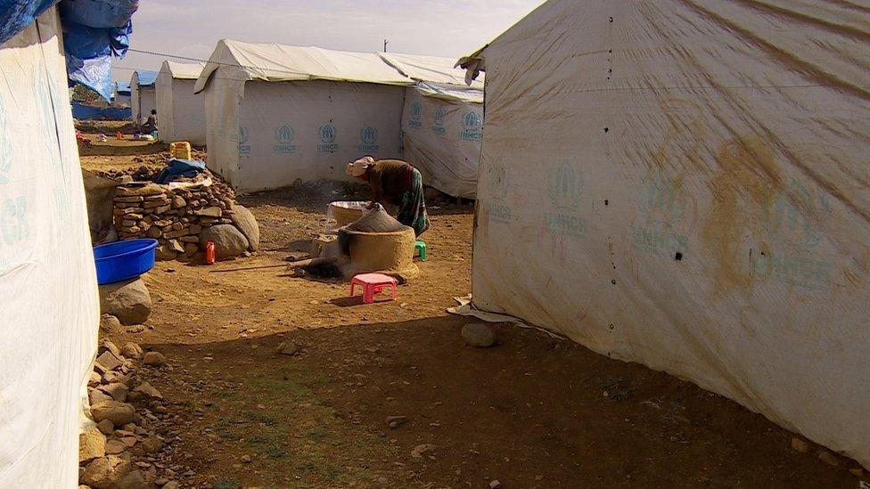 A woman is cooking in a displacement camp in Ethiopia