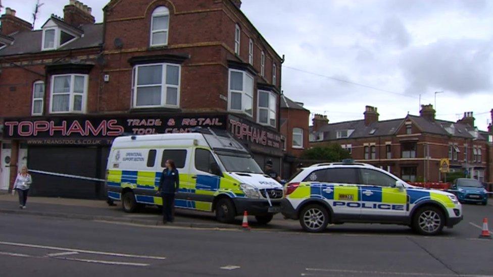 Two police vehicles parked in front of a row of houses