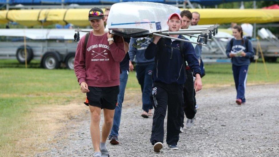 Members of the Oxford Brookes University rowing crew bring their boat back into Green's field during day one of the 2016 Henley Royal Regatta