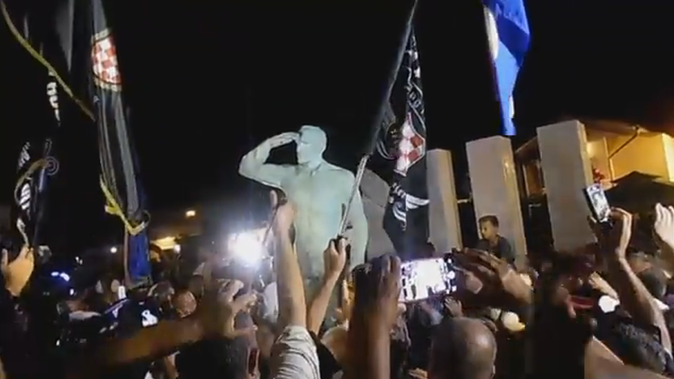 A grab from a video of the unveiling ceremony, showing crowds around the statue